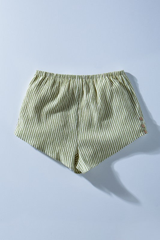 Green and white striped shorts on a light blue background
