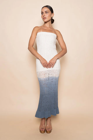 Woman wearing a strapless dress with a gradient design on a beige background