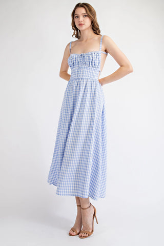 Woman wearing a blue checkered dress on a white background