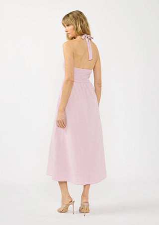 Woman wearing a pink dress with a bow detail on a white background