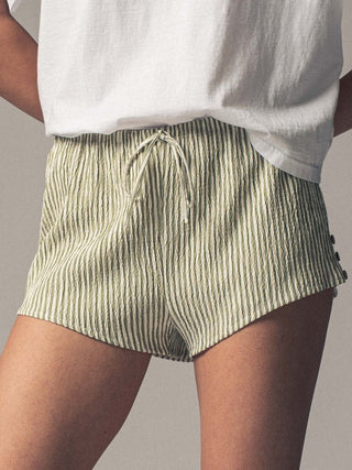 Green striped shorts worn by a person on a plain background