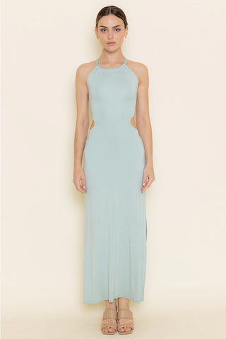 Woman wearing a light blue halter neck dress on a beige background