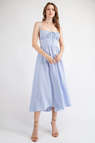 Woman wearing a blue and white checkered dress on a white background