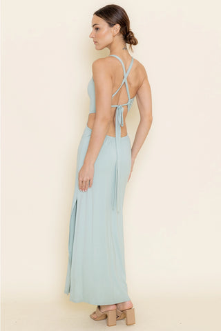 Woman wearing a light blue dress with thin straps on a beige background